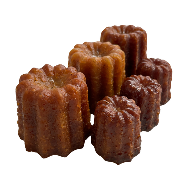 Three large and three small canelés de Bordeaux made in Bordeaux.