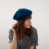 Model wearing Laulhère's 100% French merino wool Veritable beret - blue
