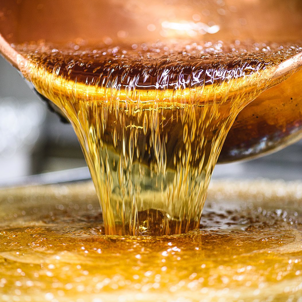 Our supplier Confiserie des Hautes Vosges pouring preparation of candies from copper cauldron at their workplace.
