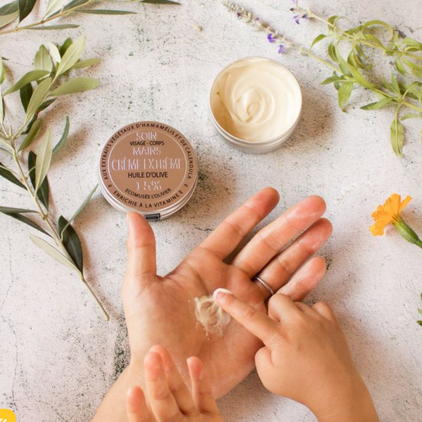 someone spreading extreme care cream on hands with one opened tin opened on the side