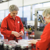 Staff busy packing jars of griottines at Distilleries Peureux workplace.