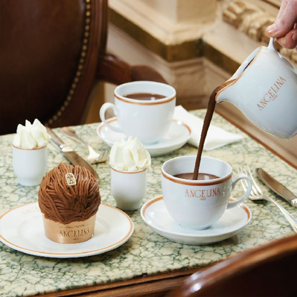 Someone pouring Angelina's hot chocolate in a cup