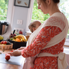 Woman busy in the kitchen and carrying her baby in Filt 1860's 100% organic cotton white mesh baby carrier - folded