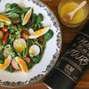 A delicious salad with eggs, tomatoes, radishes on the left and a can of Everyday Olive oil on the right.