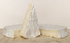 The whole Brie de Meaux in the background and one slice in the foreground
