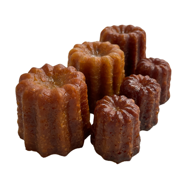 Three large and three small canelés de Bordeaux made in Bordeaux. 