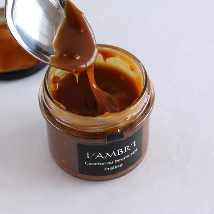 Jar of the almond &amp; hazelnut praline, salted butter caramel spread open, with a teaspoon. Ready to eat! Yummy!
