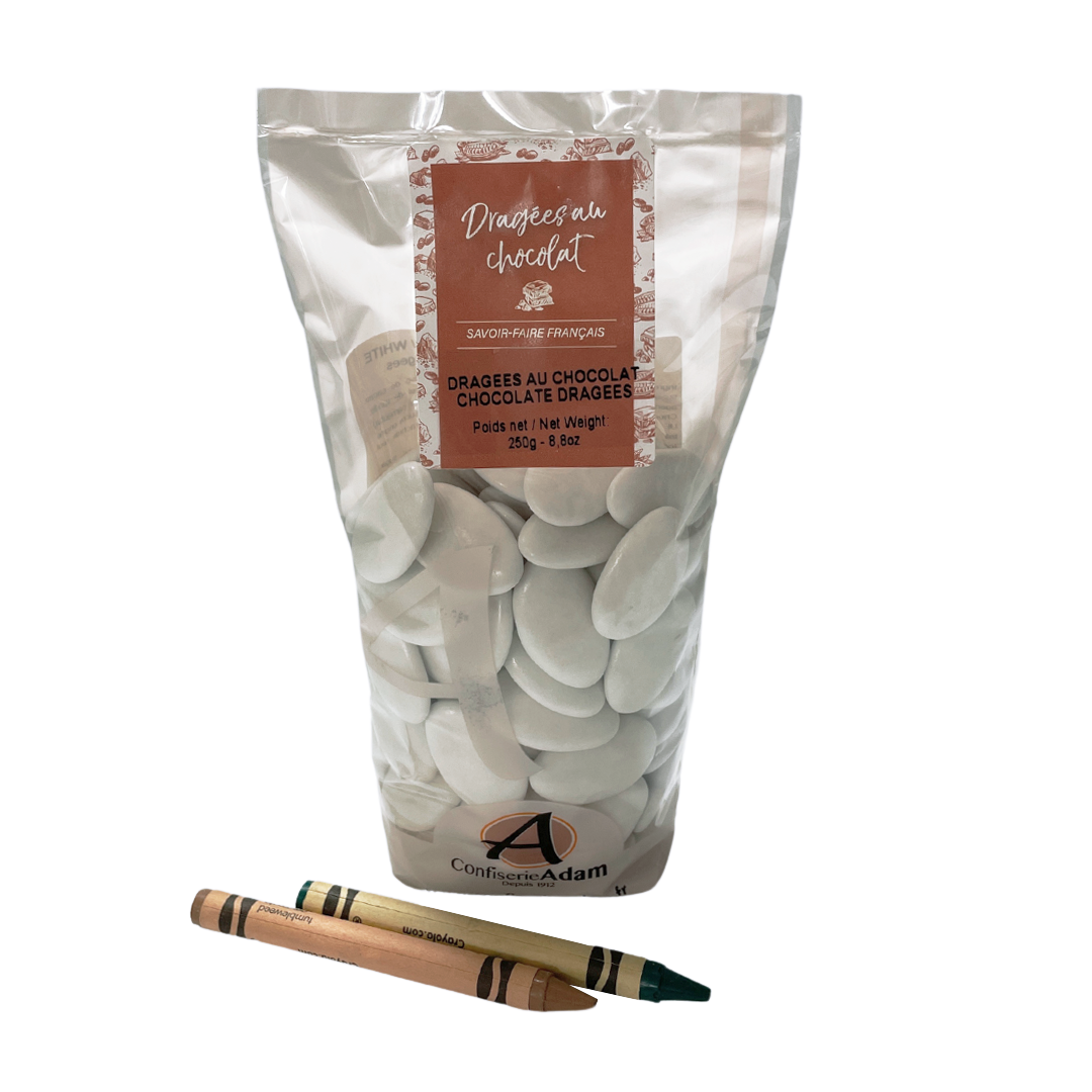 Bag of chocolate dragées with two crayons in the foreground