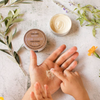 Someone spreading olive oil hand, body & face cream on hands
