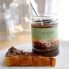 One jar of Angelina's gianduja chocolate spread in the background with some on a toast in the foreground