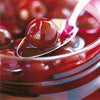 Distilleries Peureux morello cherries in an opened jar with a spoon
