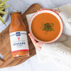 Bottle of lobster bisque with cognac with some served in a bowl on the side