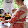 Woman busy in the kitchen and carrying her baby in Filt 1860's 100% organic cotton white mesh baby carrier  - folded