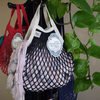 Black-ecru Filt 1860's 100% cotton net shopping bag hung with towel inside