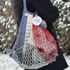 Blue-white-red Filt 1860's 100% cotton net shopping bag on someone's shoulder with warm clothes in it