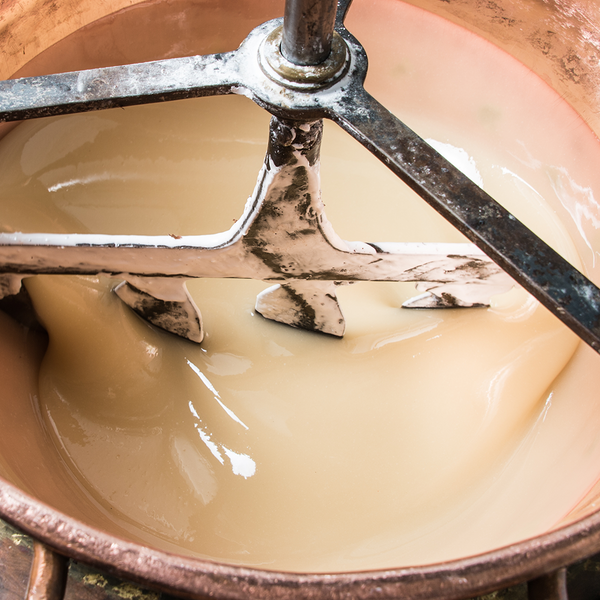 Preparation of the mixture of egg, honey & sugar in a copper cauldron at Jonquier's workplace. 