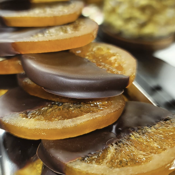 Display of slices of fresh orange slices candied and dipped in dark chocolate