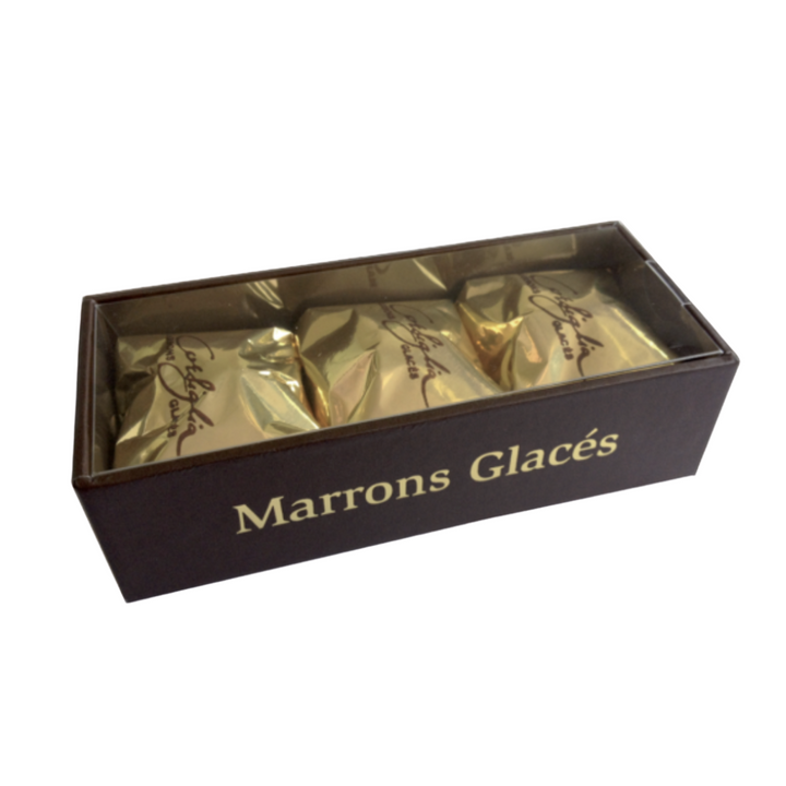 Corsiglia glazed-candied chestnuts are individually wrapped in a golden paper in a rectangular box of three with clear top &amp; Marrons Glacés written on one side. Handmade delectable treats made according to tradition. 100% natural, preservative-free.