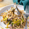 Plate with pasta and sardines with organic seaweed and capers