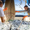 La Perle des Dieux staff at sea fishing the sardines.