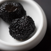 Focus on two of Artisan de la Truffe Paris' extra whole black truffles.