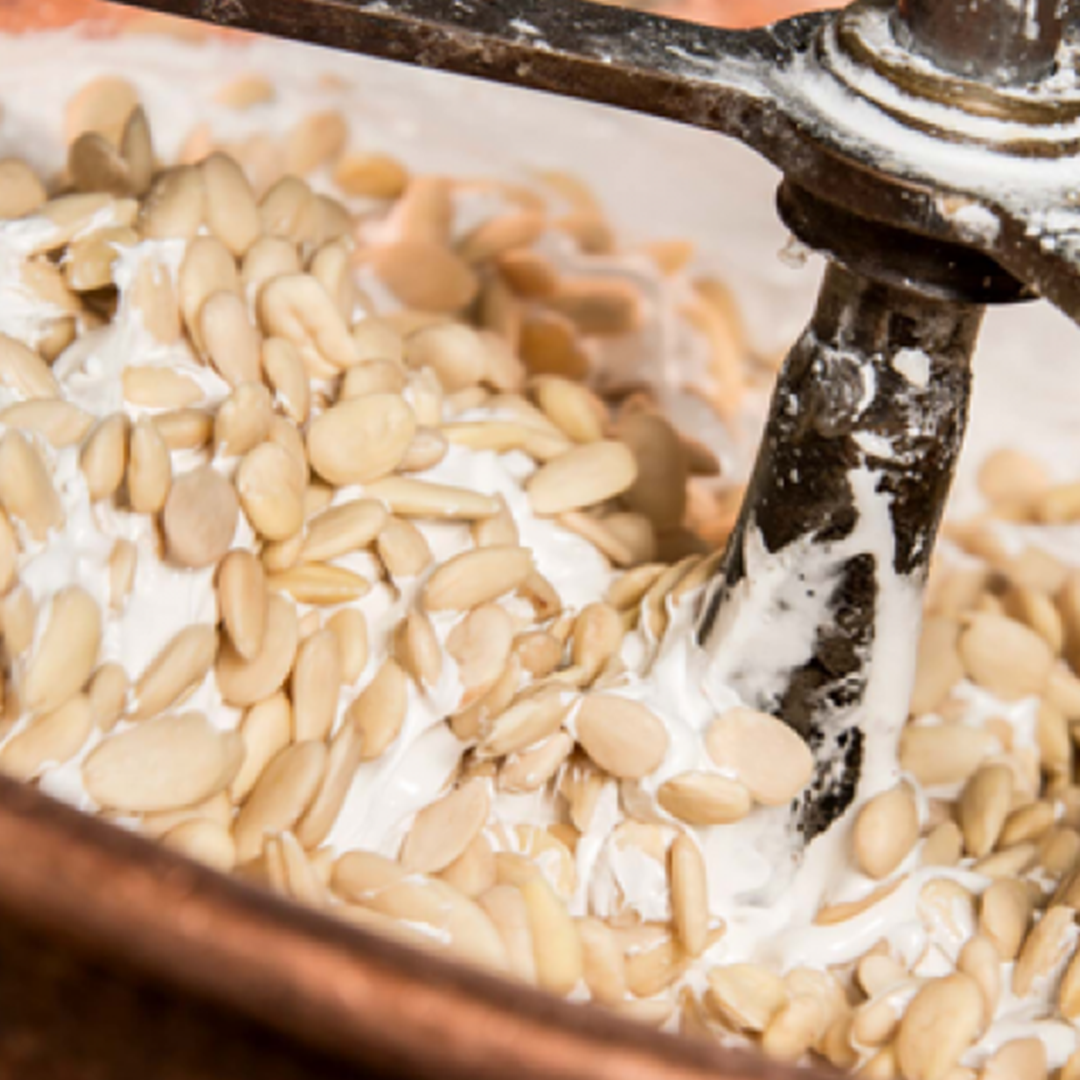 Addition of Valencia almonds from Spain to the mixture in a copper cauldron at Jonquier&